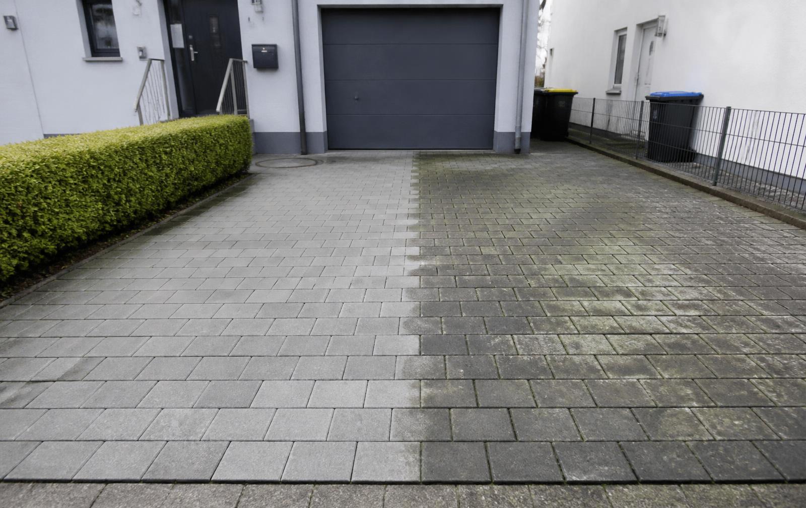 Pflastereinfahrt zur Hälfte gereinigt, links sauber, rechts mit Grünbelag