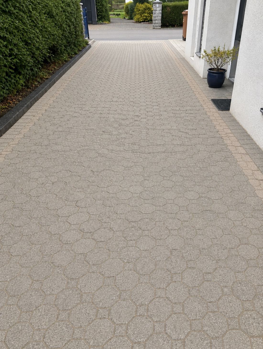 Lange Hauszufahrt mit hellem Pflaster